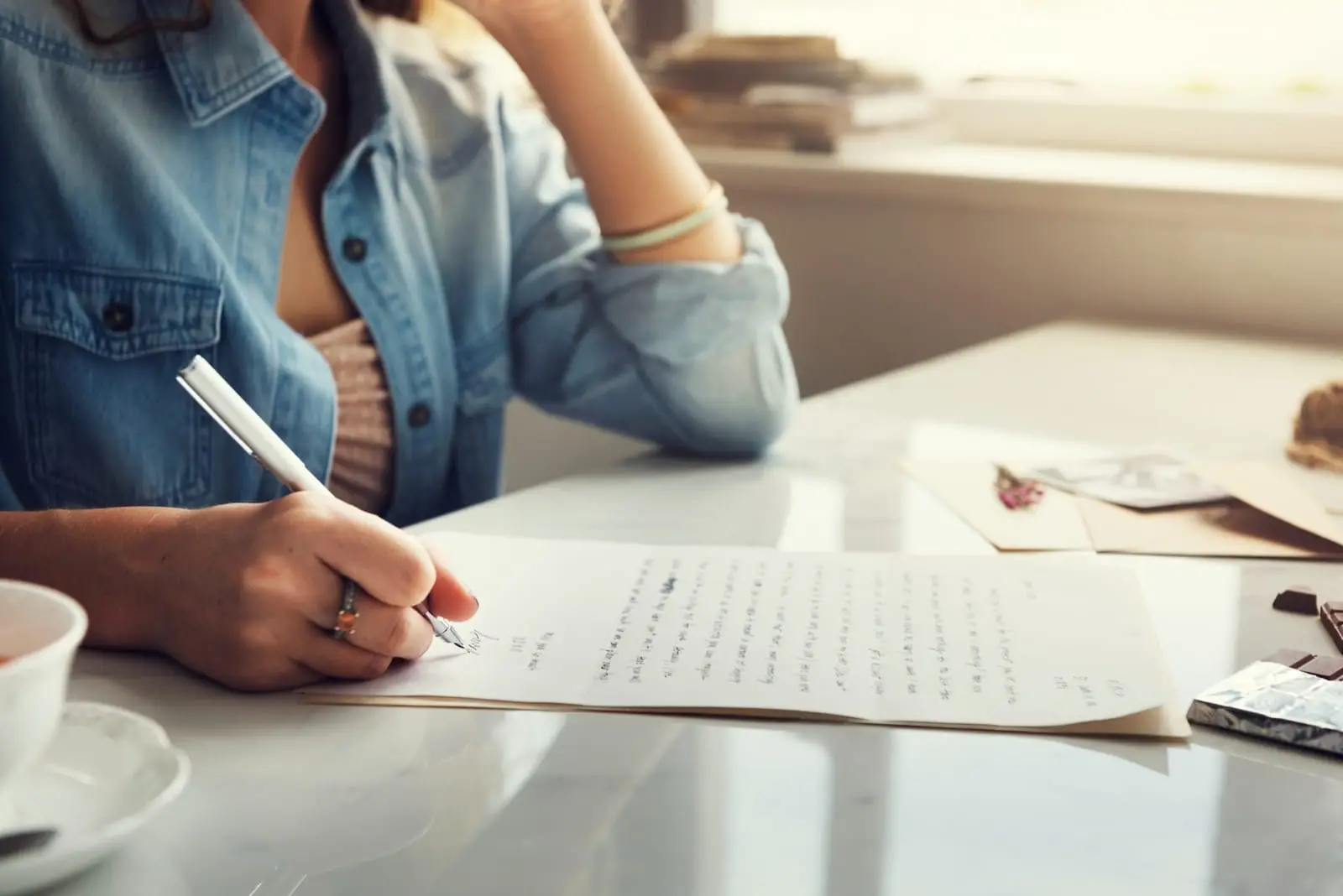 Estudante escrevendo a introdução de uma redação em folha pautada